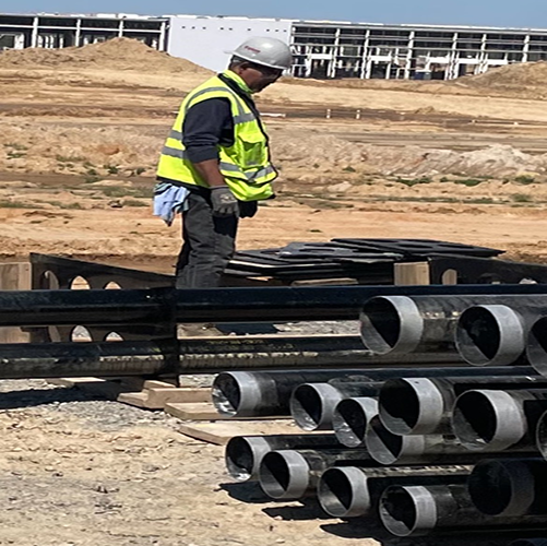 A worker standing next to conduit pipes and spacers